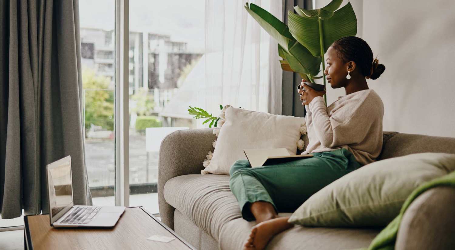 Resident having coffee in the living room at Brentwood 509 Apartments in Olympia, Washington