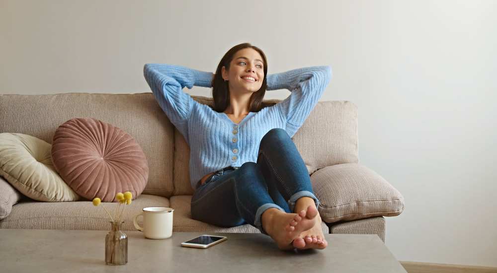 Resident relaxing on couch at Stonegate at the Crossroads in Zion Crossroads, Virginia
