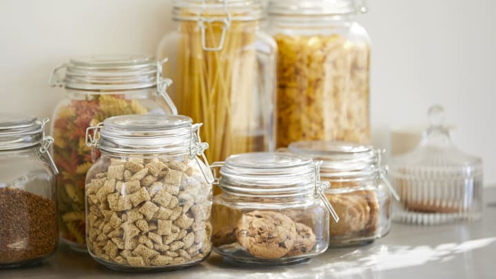 Close-up of various pantry ingredients in airtight glass containers.