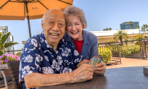 Two residents playing cards outdoors