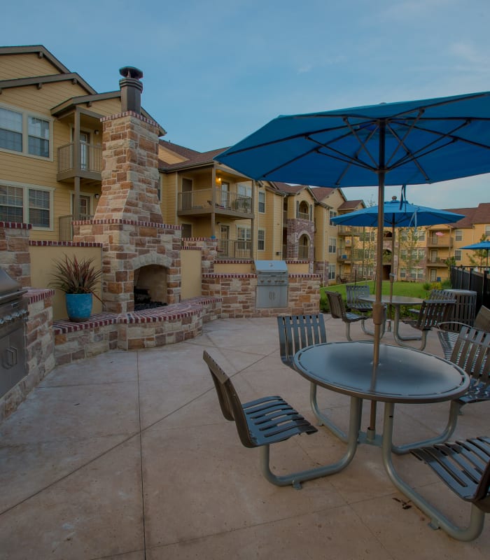 Exterior with patio umbrella seating at Cascata Apartments in Tulsa, Oklahoma