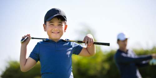 Young resident golfing with his dad near Grove Pointe in Ruskin, Florida