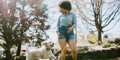 Resident taking her dog for a walk through a verdant park near Buffalo Ridge Townhomes in Elizabethtown, Kentucky