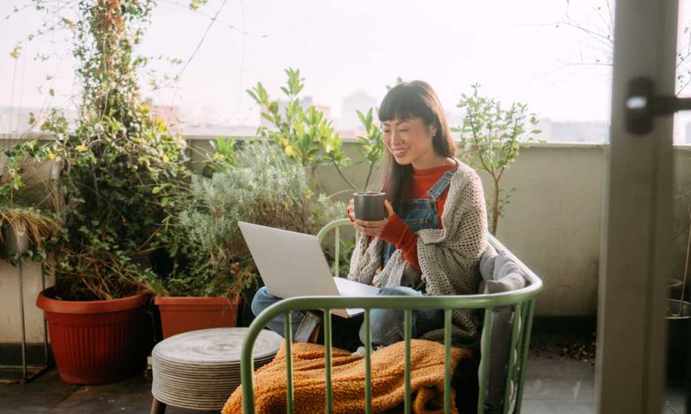 Resident working on her laptop in the balcony at Keystone Trailhead Village in Reno, Nevada