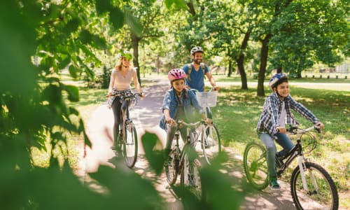 A resident family ride their bikes through the park near Courtyard in Hayward, California