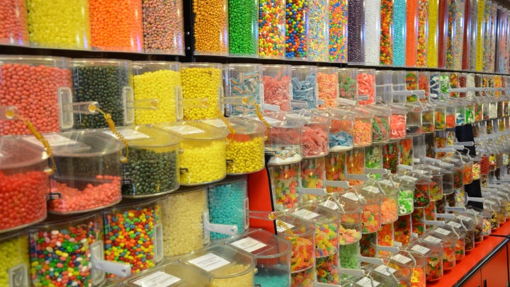 A colorful wall of bulk candy in a candy store.