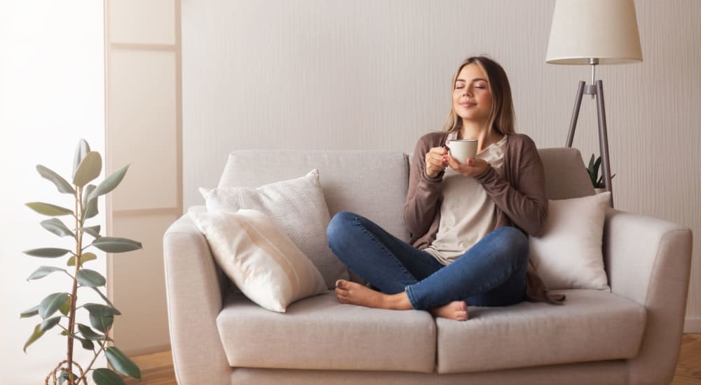 Resident relaxing with coffee at Oak Ridge Apartments in Sacramento, California