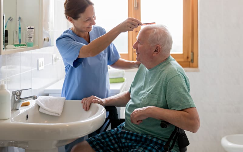 Caregiver combing a resident's hair at Arbor Rose Senior Care in Mesa, Arizona
