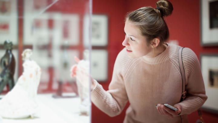 Woman in a museum looking into a glass display case