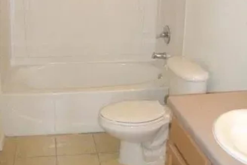 Bathroom with a toilet and a bathtub at Ochlockonee Pointe Apartments in Midway, Florida