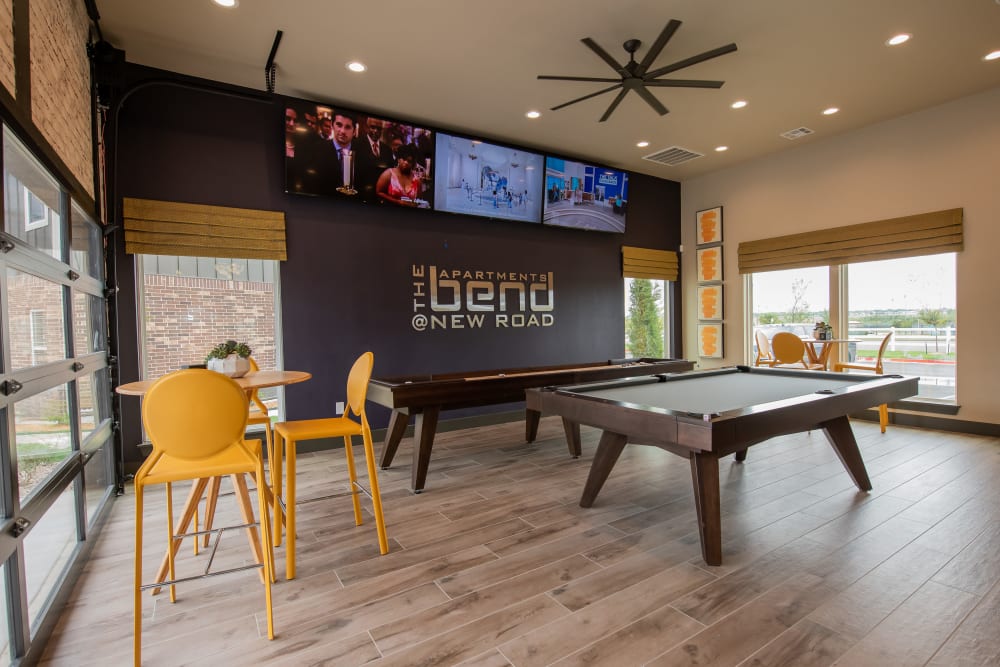 Community shuffle board and billiards table in Bend at New Road Apartments's clubhouse in Waco, Texas