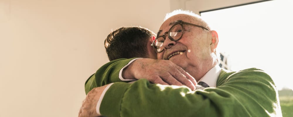 Caregiver hugging a smiling resident at The Ridge at Lapeer in Lapeer, Michigan