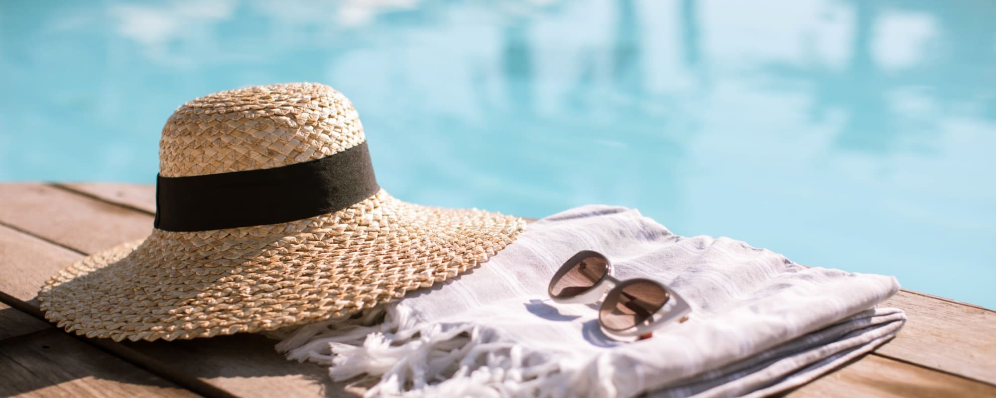 A hat and sunglasses next to a pool at Albany Hill Village in Albany, Georgia