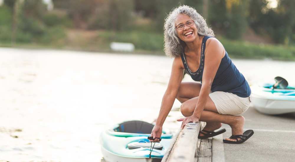 Woman next to a kayak on a dock near Bridger Peaks in Bozeman, Montana