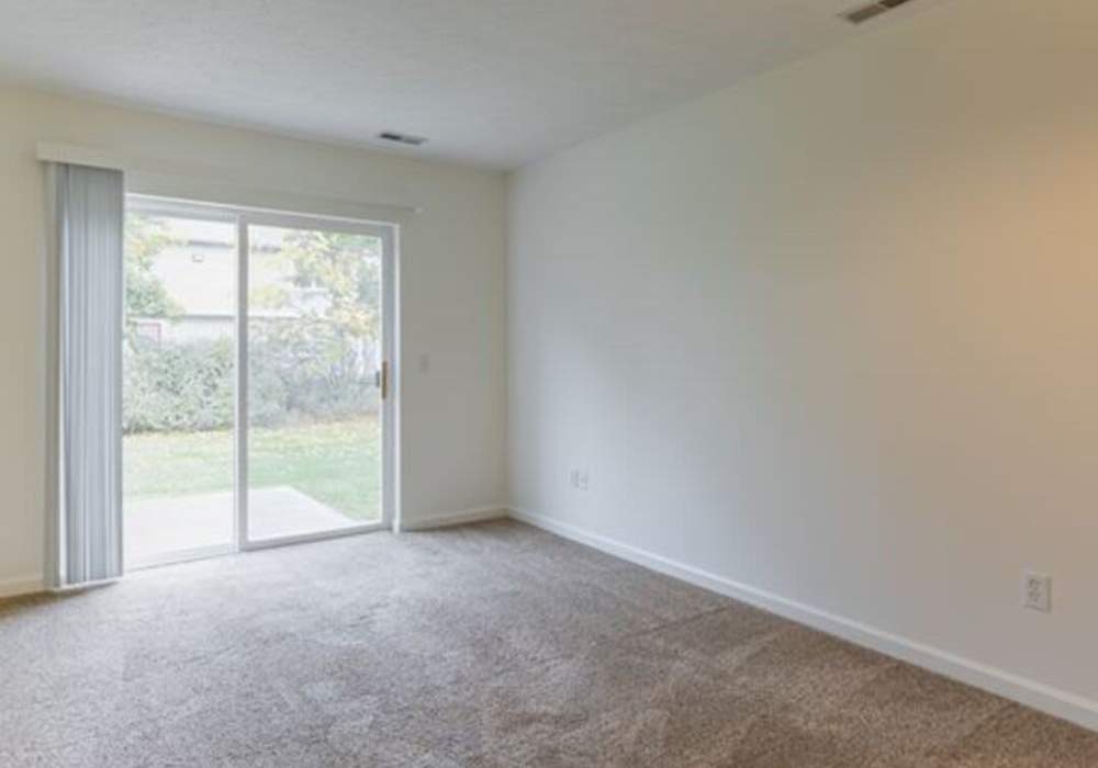 Bedroom with carpet flooring and sliding glass door to outdoor space at North Road Townhomes in Scottsville, New York