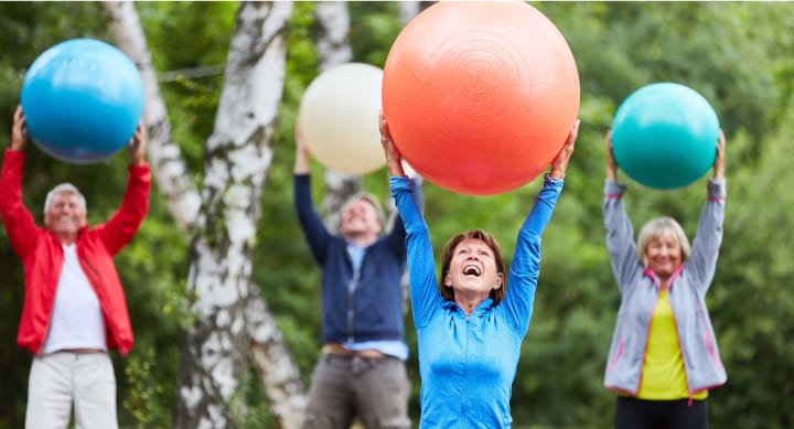 Seniors with exercise balls outside