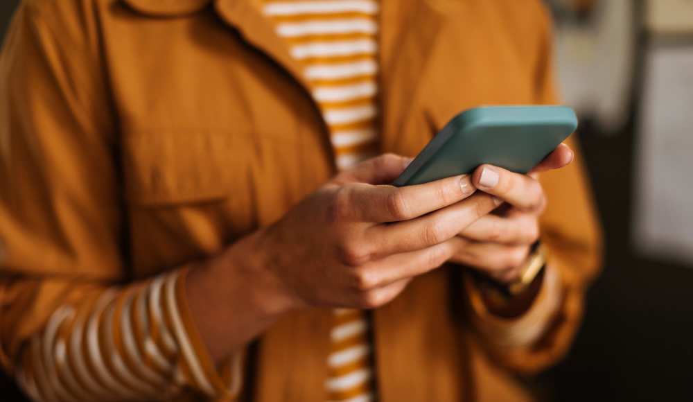 Resident using his mobile at Ochlockonee Pointe Apartments in Midway, Florida