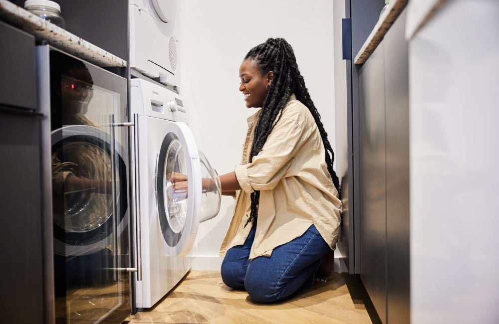 Resident loading clothes in to the washer at Athena Garden Apartments in Athens, Texas