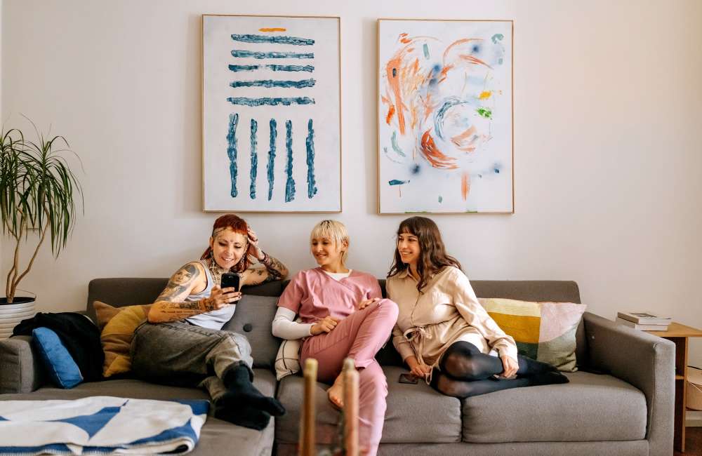 Residents relaxing on a sofa in a bright community lounge at Stonebridge Crossing Apartment Homes in Cordova, Tennessee