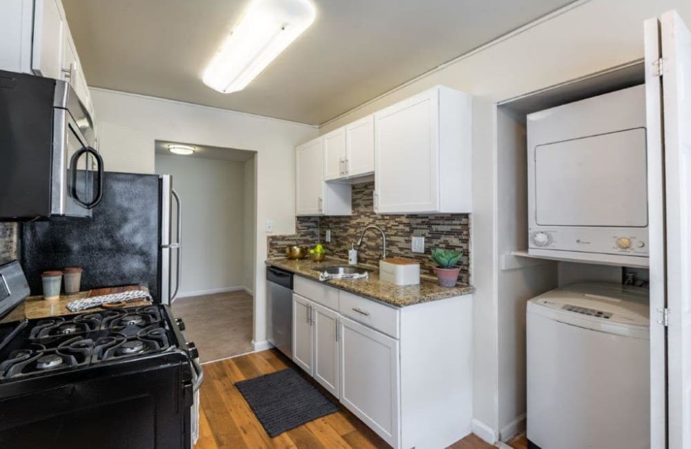 Kitchen with white cabinets and in-unit laundry at Chesapeake Glen Apartment Homes in Glen Burnie, Maryland