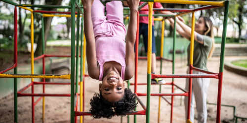 Resident daughter playing in community playground at Voorhis Village Apartments in San Dimas, California