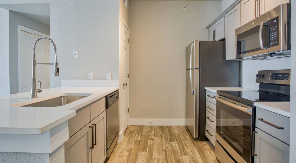 Kitchen with range, stainless-steel sink and refrigerator at Chandler At University Tower in Durham, North Carolina 