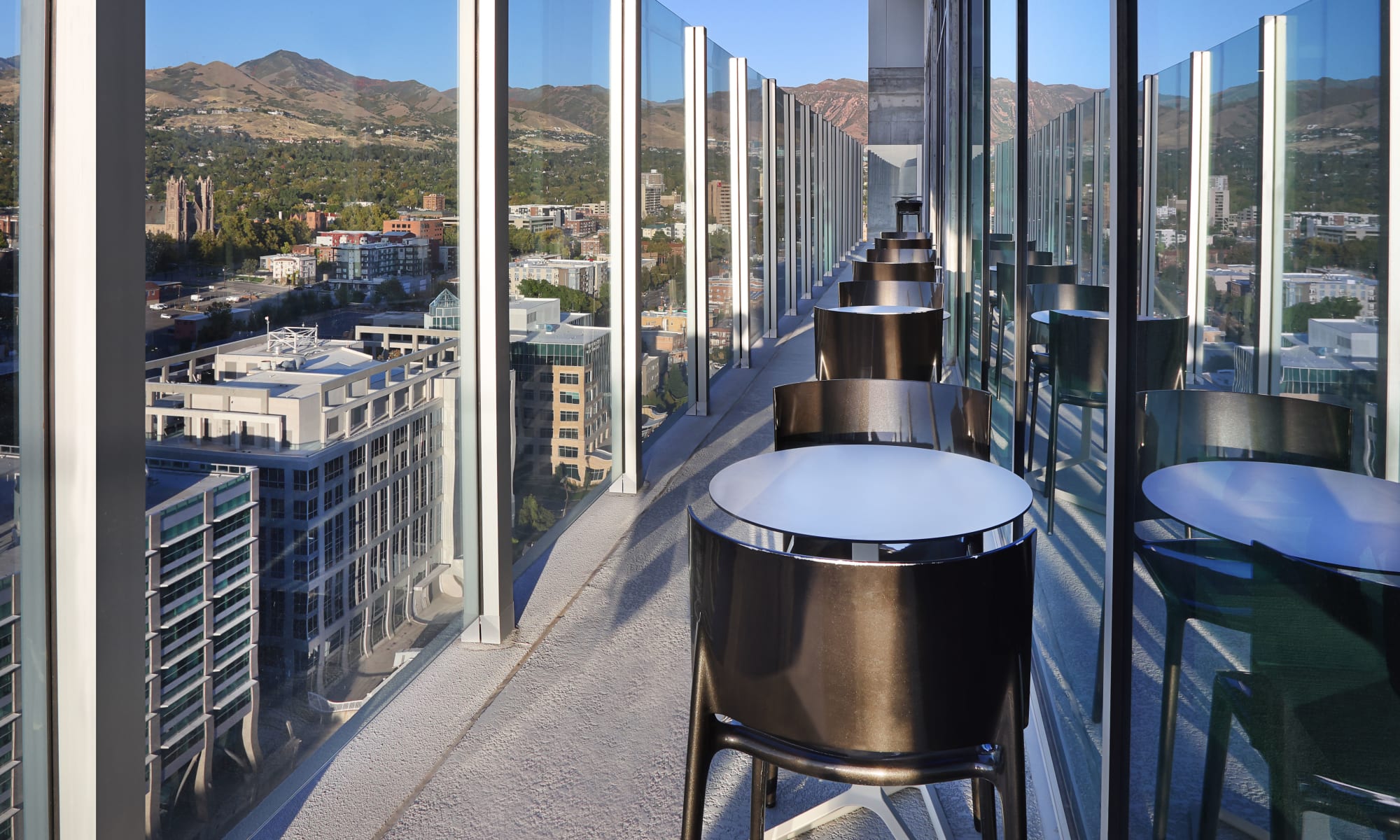 Stools and tables with a mountain and city view at Luxury high-rise community of Liberty SKY in Salt Lake City, Utah