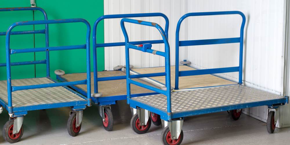 A trio of blue trolley carts with wheels in self-storage unit at Wilder Storage, Wilder, Kentucky
