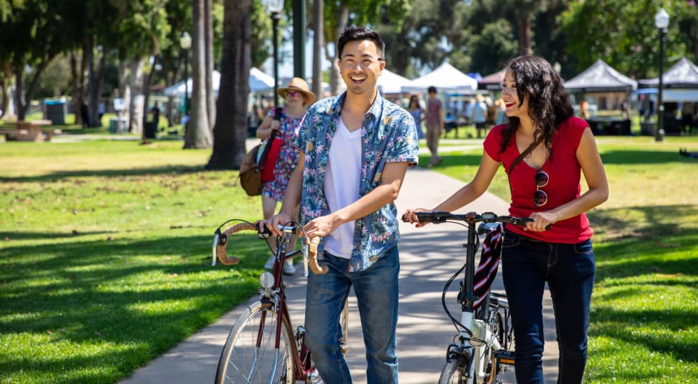 Residents walking their bikes in a park near Country Club Village in Stockton, California