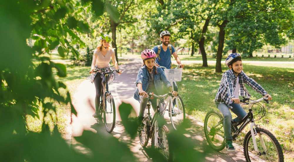 Resident family biking near the green trail at Midtown Square Chattanooga Apartments in Chattanooga, Tennessee