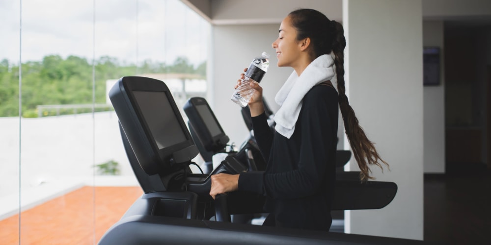 A resident drinking water on the treadmill at Mosby Poinsett in Greenville, South Carolina