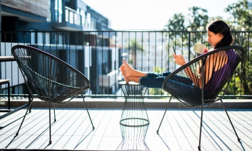 A resident reads a book on her private balcony at Marina Breeze in San Leandro, California