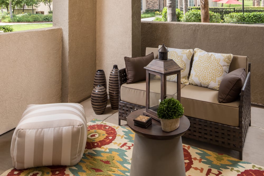 Private back patio with comfortable lounge chairs at Esplanade Apartment Homes in Riverside, California