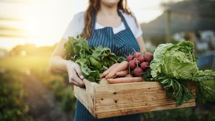 Woman carrying a crate of vegetables