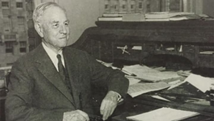 R.D Merrill sits at desk 