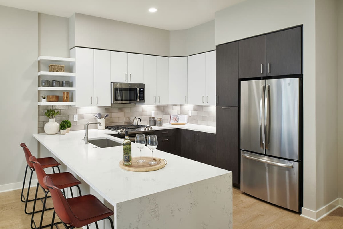 Wood-style flooring and stainless-steel appliances in an apartment kitchen at Epoque in Golden, Colorado