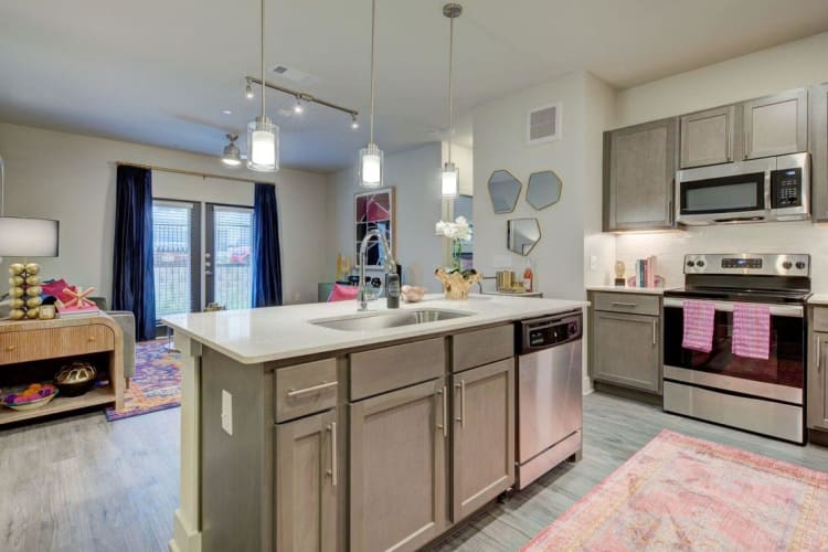Kitchen with kitchen island and view of living room at Palmetto Pointe in San Antonio, Texas