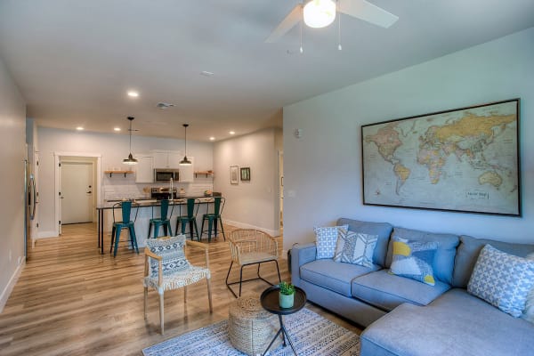 Living area with hardwood floors and ceiling fan in open-concept floor plan of model home at District Lofts in Gilbert, Arizona