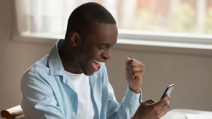 Man looking at smartphone excited about Fantasy Football at Wimberly at Deerwood