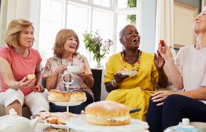 Friends laughing and eating pastries at Widdicombe Place in Etobicoke