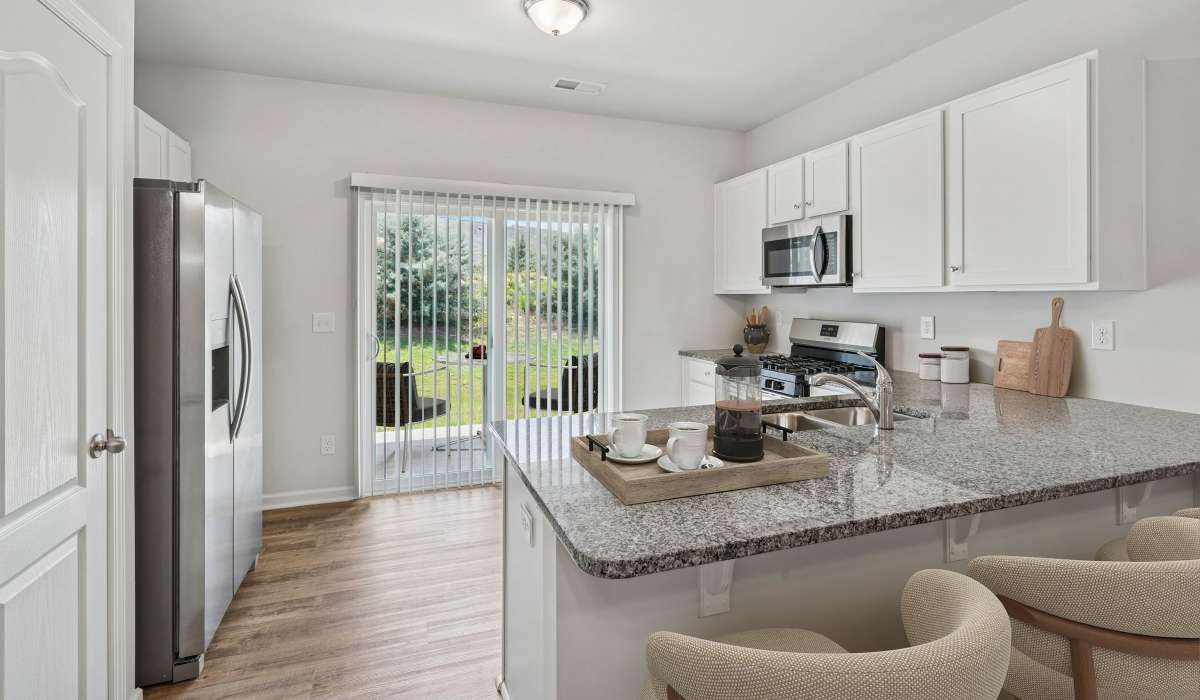 Kitchen with refrigerator and wooden cabinets room at Poplin Trace in Indian Trail, North Carolina