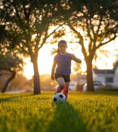 Resident child playing soccer at a park near 5 Row in Charlottesville, Virginia