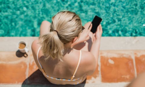 A woman relaxing by the pool at Redwood Plaza in Fremont, California