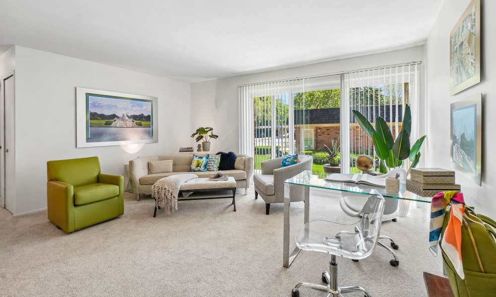 Model living room opening onto a private patio at Kensington Manor Apartments in Farmington, Michigan