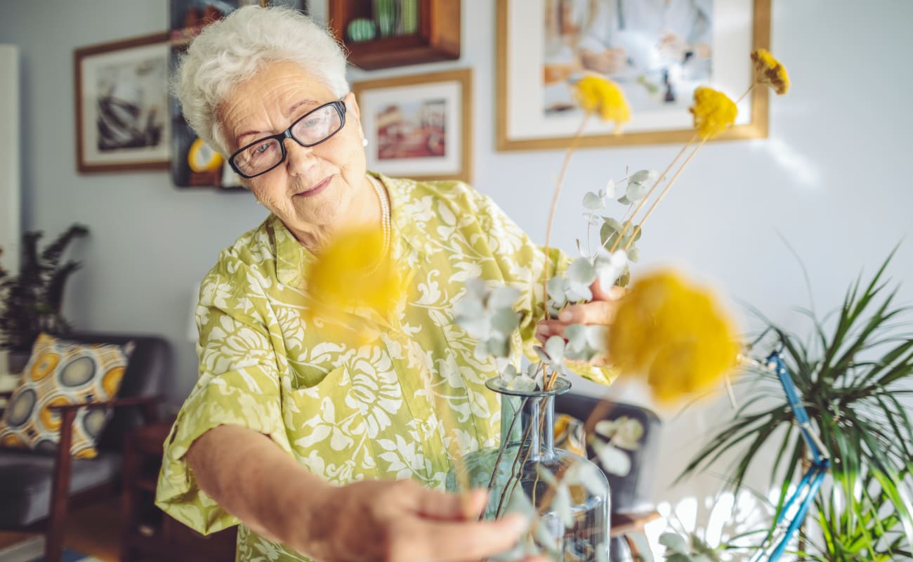 A resident putting flowers in a vase at Merrill Gardens at Campbell in Campbell, California.