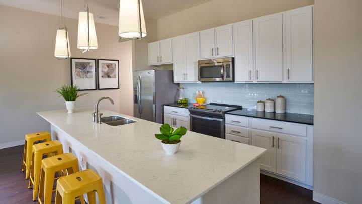 Kitchen and bar with appliances including refrigerator, microwave, oven, and cupboard storage at 