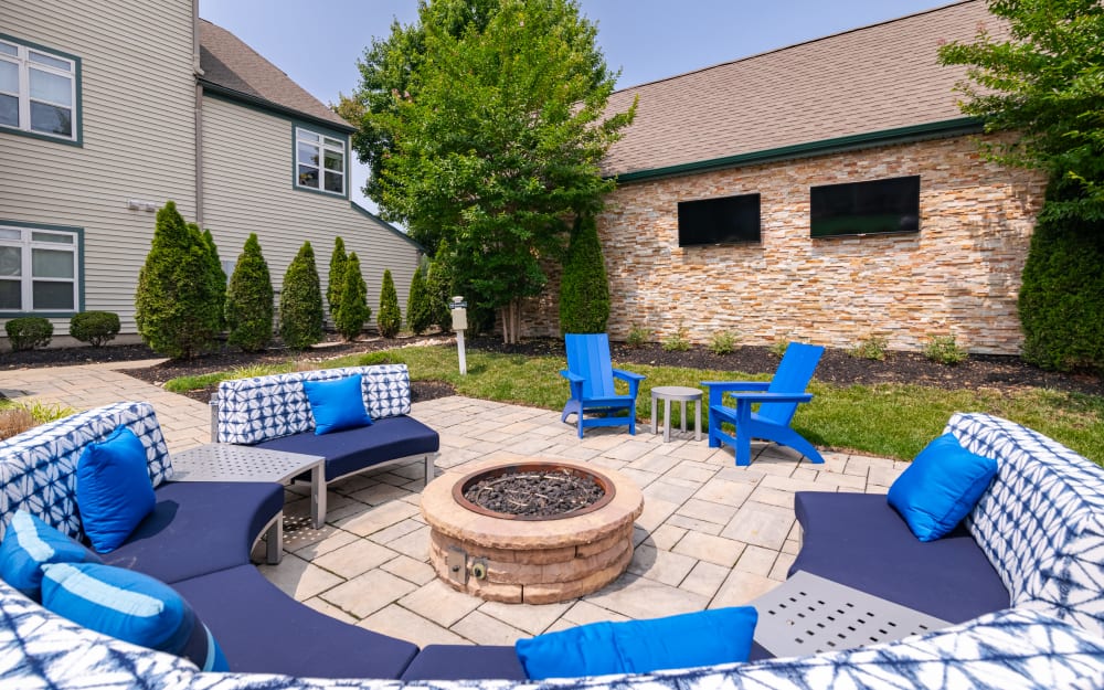 Fire pit with seating and outdoor TVs at Bishop's View Apartments & Townhomes in Cherry Hill, New Jersey