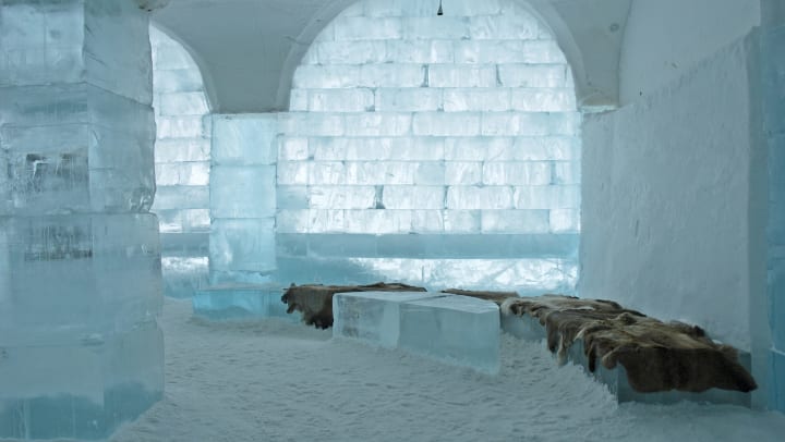 A room made of ice with furs on ice blocks.