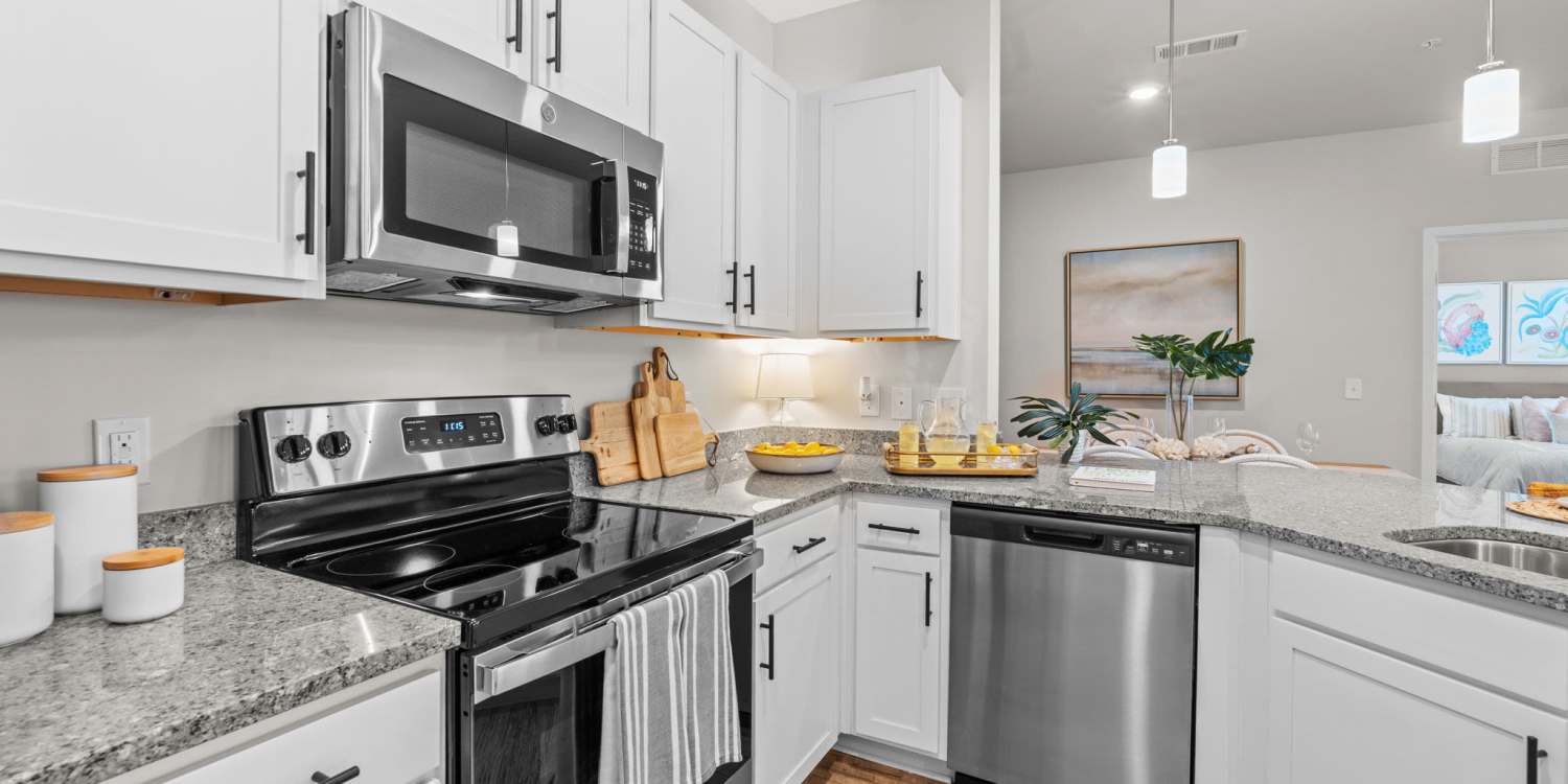 Kitchen with stainless steel appliances and white cabinets at Mexico Beach Crossings.