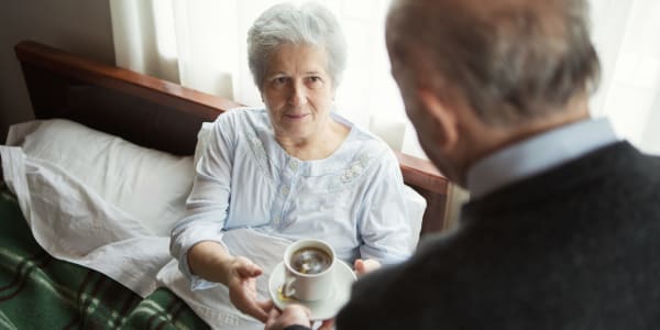 Resident in bed being served a cup of coffee at Wellington Meadows in Fort Atkinson, Wisconsin